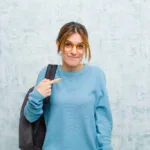 Młoda dziewczyna w niebieskim swetrze po zajęciach studenckich