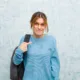 Młoda dziewczyna w niebieskim swetrze po zajęciach studenckich
